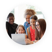 teacher with students surrounding her while on the computer