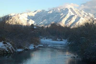 Mountains covered in snow with a large lake below it